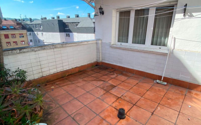 Interior de vivienda reformada con suelo de madera y mural de fotografía en pared